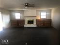 Bright living room with a white brick fireplace, built-in shelving, and dark carpet at 1045 Springway Dr, Shelbyville, IN 46176