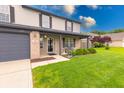 Inviting front exterior showcasing a well-kept lawn, lovely landscaping, and a charming covered front porch at 1199 Oak Leaf Rd, Franklin, IN 46131