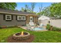 Cozy backyard features a fire pit, patio seating, pergola, and privacy fence at 1240 Hamilton Dr, Noblesville, IN 46060