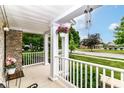 Cozy porch with white railing, hanging flower basket, and relaxing wind chimes at 12994 Dekoven Dr, Fishers, IN 46037