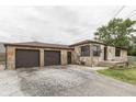 Stone home with two-car garage and long driveway, offering ample parking and curb appeal at 1601 Southern Ave, Beech Grove, IN 46107