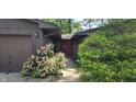 Inviting entrance featuring a stone facade, a two-car garage, flower beds, and mature landscaping at 1619 Crest Ct, Indianapolis, IN 46214