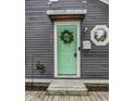 Close-up of a mint-green front door with a 'Welcome' wreath and modern accents at 1841 New St, Indianapolis, IN 46203