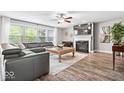 Cozy living area with large windows, fireplace, and stylish grey sectional sofa at 19534 Forsythe Dr, Noblesville, IN 46060