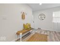 Bright entryway features stylish bench seating, hooks, and wood laminate flooring at 2105 Mayfair Dr, Indianapolis, IN 46260