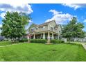 Inviting two-story home featuring a covered front porch and lush green lawn at 241 N Liberty Blvd, Mooresville, IN 46158