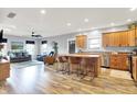 Open kitchen with stainless appliances, island with bar stool seating, and view into the spacious living room at 241 Liberty Blvd, Mooresville, IN 46158