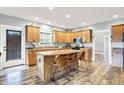 Well-lit kitchen featuring a kitchen island with bar stool seating, wooden cabinets, and stainless steel appliances at 241 Liberty Blvd, Mooresville, IN 46158