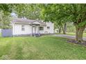 Quaint home with a lush green lawn and mature trees providing shade at 3409 S Rural St, Indianapolis, IN 46237