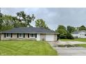 Charming one-story home with a well-maintained lawn, stone exterior, and attached garage at 4004 N Ball Ave, Muncie, IN 47304