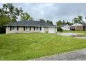 Charming one-story home with a well-maintained lawn, stone exterior, and attached garage at 4004 N Ball Ave, Muncie, IN 47304