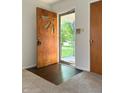 Bright foyer with a uniquely styled wooden front door and wood flooring at 403 Us Highway 31 N, Greenwood, IN 46142