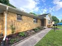 View of the home's exterior featuring brickwork, garden beds, and a well-kept sidewalk leading to the front door at 403 Us Highway 31 N, Greenwood, IN 46142