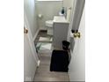 Compact bathroom with a gray vanity, modern toilet, and a mix of patterned and solid rugs at 4113 W 30Th St, Indianapolis, IN 46222