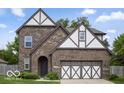 Charming brick home featuring a two-car garage, well-maintained lawn, and traditional architectural details at 4689 Muscatine Way, Westfield, IN 46062
