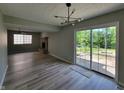 Open-concept living room with hardwood floors, brick fireplace, and sliding glass doors leading to outdoor space at 5239 Traditions Rd, Indianapolis, IN 46235