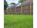 Fenced backyard featuring a well-maintained lawn, offering privacy and space for outdoor activities at 5903 Brookville Lake Dr, Indianapolis, IN 46254