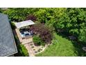 A patio area with a blue cushioned seating set around a fire table and a manicured lawn at 5350 Chico Grey Dr, Indianapolis, IN 46237