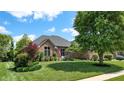 Charming single-Gathering home with a well-manicured lawn, mature trees, and tidy landscaping at 5350 Chico Grey Dr, Indianapolis, IN 46237