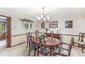 Traditional dining room with wainscoting, wallpaper and an oval dining table at 577 Century Oaks Dr, Zionsville, IN 46077