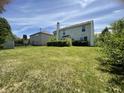Spacious backyard ideal for entertaining, showcasing green grass, trimmed bushes, bright sunlight, and a partial rainbow at 5920 Copeland Mills Dr, Indianapolis, IN 46221