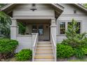 Close up of a well maintained and landscaped home showcasing a porch with seating and light colored siding at 595 W Poplar St, Zionsville, IN 46077