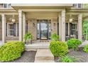 Inviting front porch with brick facade, decorative plants, rocking chairs, and a stylish front door at 6168 Pine Bluff Dr, Avon, IN 46123