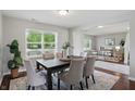 Elegant dining room featuring a dark wood table set for six, with bright natural light at 6552 Hunters S Rdg, Zionsville, IN 46077