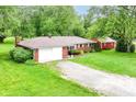 Aerial view of a brick ranch-style home with large front yard and gravel driveway at 7050 N County Road 650 E, Brownsburg, IN 46112