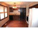 Kitchen with dark wood cabinets, hardwood floors, and a bright, sunny window at 7931 Guion Rd, Indianapolis, IN 46268