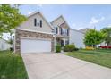 Two-story home with stone and siding, featuring a two-car garage, and well-maintained front lawn at 8710 N Aspen Way, McCordsville, IN 46055