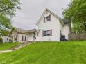 A quaint home with a well-manicured lawn and a charming enclosed front porch at 907 S A St, Elwood, IN 46036
