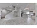 Open-concept living room with high ceilings, staircase, and seamless flow into a modern kitchen at 9317 E 36Th Pl, Indianapolis, IN 46235