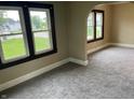 Carpeted living room with two windows offering plenty of natural light at 1020 E 30Th St, Anderson, IN 46016