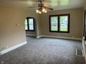 Carpeted living room with natural light and open archway to another room at 1020 E 30Th St, Anderson, IN 46016