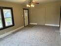 Neutral carpeted living room with abundant natural light and ceiling fan at 1020 E 30Th St, Anderson, IN 46016