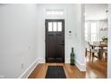 Bright foyer with hardwood floors and stylish front door, leading to dining area at 1034 N Tacoma Ave, Indianapolis, IN 46201