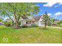 Beautiful two-story house featuring a covered porch, a manicured lawn, and mature trees, creating a serene and inviting atmosphere at 10717 Morristown Ct, Carmel, IN 46032