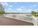 Spacious wooden deck with white railing, offering scenic views of the tranquil lake at 11065 Spice Ln, Fishers, IN 46037