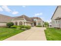 Charming home with stone accents, lush landscaping, and a spacious driveway at 11065 Spice Ln, Fishers, IN 46037