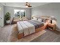 Bright bedroom with large windows, soft carpet, and neutral decor featuring seating area and ceiling fan at 11753 Pawleys Ct, Indianapolis, IN 46235