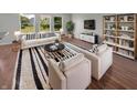 Bright living room with stylish decor, including a modern sofa, armchairs, and a unique rug at 11753 Pawleys Ct, Indianapolis, IN 46235