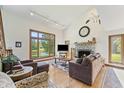 Bright living room with stone fireplace, large windows offering views, and plush seating, perfect for relaxing and entertaining at 11875 W 700 S, Columbus, IN 47201