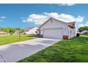 Exterior view showcasing the home's two-car garage and well-kept lawn at 12250 Longstraw Dr, Indianapolis, IN 46236