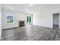 Bright living room featuring a fireplace, sliding glass doors to deck, and modern flooring at 12250 Longstraw Dr, Indianapolis, IN 46236