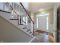 Inviting foyer featuring tile flooring, staircase with wooden railing, and natural light streaming through the front door at 13271 Aquamarine Dr, Carmel, IN 46033
