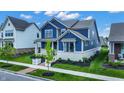 Eye-level view of a two-story home featuring a well-manicured lawn, mulch beds, and a brick walkway at 1364 Chatham Hills Blvd, Westfield, IN 46074