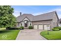 Beautiful brick home featuring a three-car garage, landscaped front yard, and stone entryway at 14711 Macduff Dr, Noblesville, IN 46062