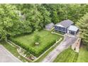 Overhead view of a blue home featuring well-maintained landscaping, a detached garage, and lots of greenery at 1513 Alimingo Dr, Indianapolis, IN 46260