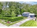 Aerial view of blue home with large lawn and well-manicured hedges, surrounded by lush, mature trees at 1513 Alimingo Dr, Indianapolis, IN 46260